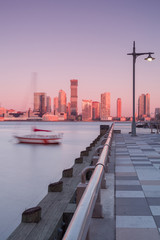 View on jersey city from the pier with floating boat during sunrise