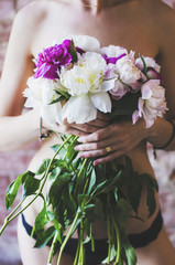 Girl in black underwear with bunch of flowers covering her sensual body