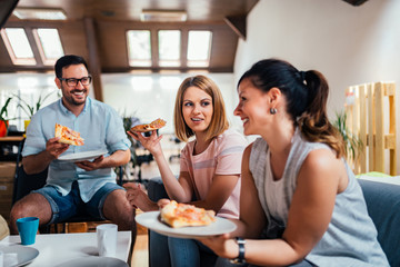 Beautiful caucasian people having pizza indoors.