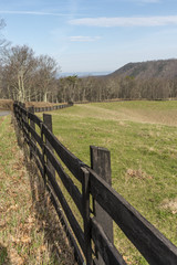 Fototapeta na wymiar Wooden fence twisting beside the field