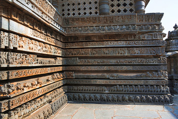 Friezes of animals, scenes from mythological episodes from Ramayana and Mahabharata, at the base of temple, Hoysaleshwara temple, Halebidu, Karnataka. View from South.