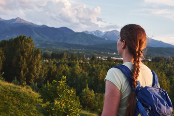 Young tourist woman looking at the peaks of the Almaty mountain. Almaty, Kazakhstan