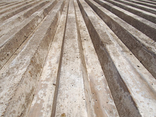 close up of cast concrete with vertical ribbed texture with a converging view in sunlight and shadow