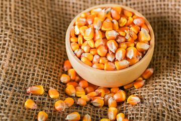 Close up corn seeds in bowl on beige cloth