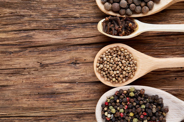 Row of wooden spoons with spices on vintage background, close-up, selective focus, vertical.