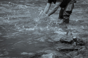 gold panner on the river who plays with the water; black and white colored