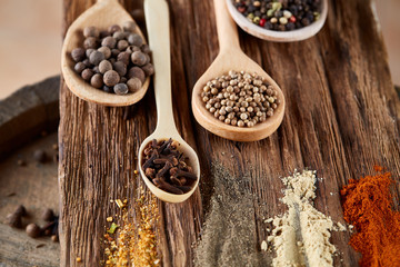 Row of wooden spoons with spices on vintage background, diminishing perspective, close-up, selective focus