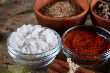 Spices in ceramic bowls on the top of wooden barrel, close-up, selective focus, vertical.