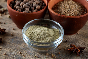 Spices in ceramic bowls on the top of wooden barrel, close-up, selective focus, vertical.