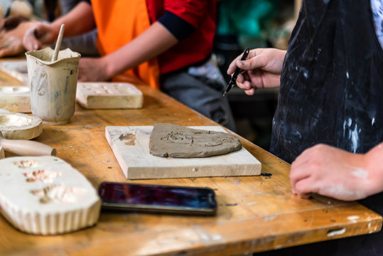 Pottery workshop. hands make print on clay