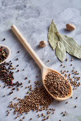 Composition with aromatic peppercorn in the wooden spoons on the white background, flat lay, close-up, selective focus.
