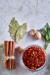 Culinary still life of assorted spices on white textured background, flat lay, close-up, selective focus.