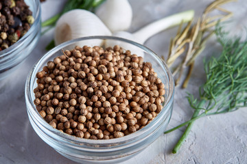 Coriander in glass bowl with clipping path on white background, top view, selective focus, vertical.