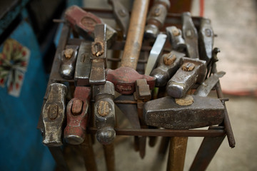 Working metal tools in blacksmith's workshop, close-up, selective focus, nobody