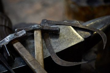 Working metal tools in blacksmith's workshop, close-up, selective focus, nobody