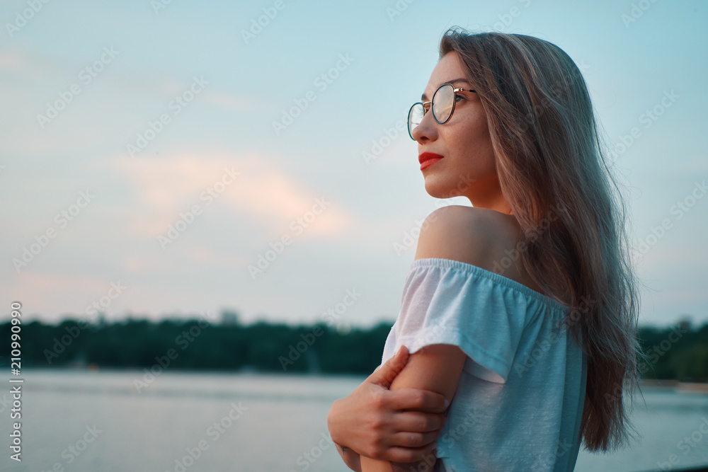 Wall mural attractive girl wearing glasses on park lake view