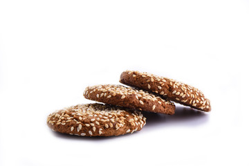 Three oatmeal cookies with sesame seeds isolated on white