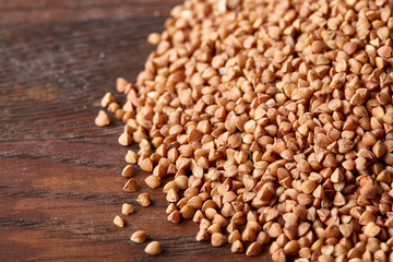 Buckwheat groats on wooden background, top view, close-up, selective focus, shallow depth of field