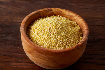 Lentils in a wooden bowl on rustic wooden background, top view, close-up, selective focus.