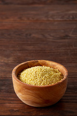 Lentils in a wooden bowl on rustic wooden background, top view, close-up, selective focus.