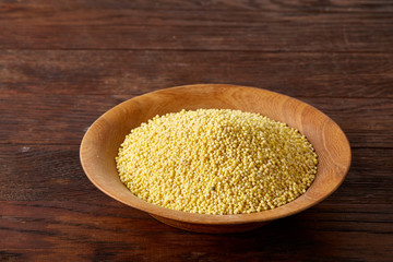 Lentils in a wooden bowl on rustic wooden background, top view, close-up, selective focus.