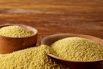Lentils in a wooden bowl on rustic wooden background, top view, close-up, selective focus.