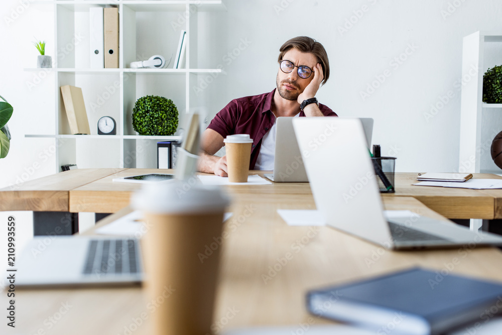 Wall mural tired handsome businessman working on startup project in office and looking away