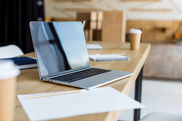 laptop on wooden table in business office