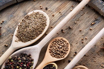 Colourful aromatic various spices for cooking on old wooden board, close-up, flat lay, selective focus.