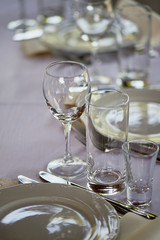 Classic table setting. Appliances, glasses, white tablecloth and plate