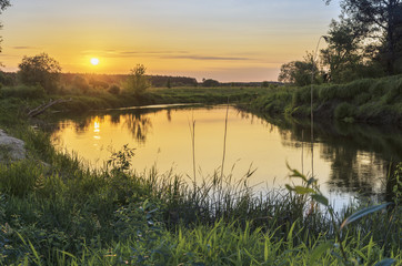 Picturesque fairy sunrise over the meadow, the forest and river in summer morning