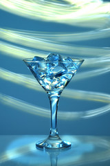  a martini glass with ice cubes on a blue background