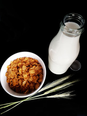 Milch im Glas mit Flasche auf schwarzem Hintergrund