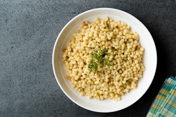 Cooked Couscous with Dill served in White Plate / Turkish Kuskus