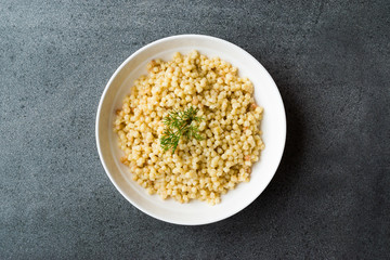 Cooked Couscous with Dill served in White Plate / Turkish Kuskus