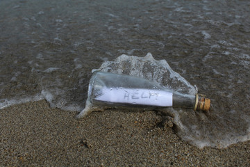 message d'appel au secours dans un bouteille lancée dans la mer