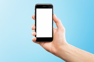 Male hand holding black cellphone isolated at blue background.