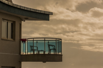 a terrace with two chairs at a hotel overlooking the sea and the ocean, against the background of beautiful clouds glowing during the sunset. sunrise in a seaside resort.