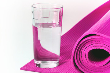 colored mat for fitness, yoga and glass of water