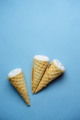 ice cream on a blue background, three wafer horns, top view, place for text