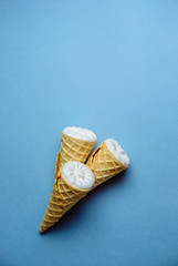 ice cream on a blue background, three wafer horns, top view, place for text