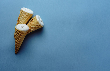 Naklejka premium ice cream on a blue background, three wafer horns, top view, place for text