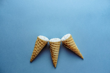 ice cream on a blue background, three wafer horns, top view, place for text