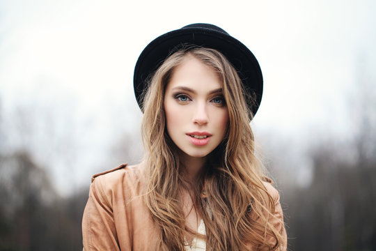 Cheerful woman in hat outdoors. Healthy female face