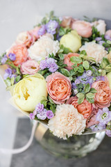 Work florist. Beautiful spring bouquet. Arrangement with mix flowers. The concept of a flower shop, a small family business. Pastel Color.