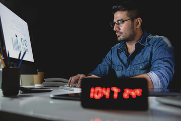 Workaholic man working overtime late at night in the office