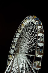 selective focus of illuminated observation wheel at night on black background