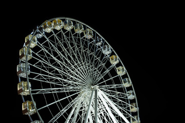 selective focus of illuminated observation wheel at night on black background