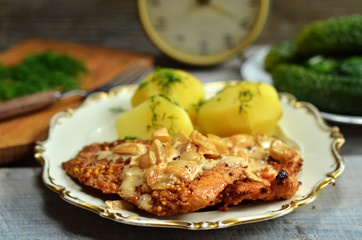 Fried pork fillets with potatoes on a rustic plate