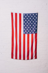 close up view of american flag hanging on white brick wall © LIGHTFIELD STUDIOS